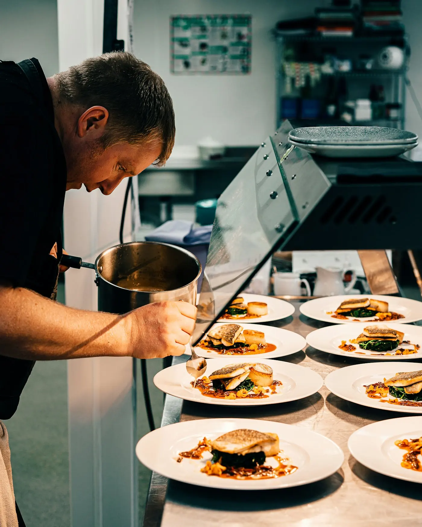 Un cuisinier dresse une série d’assiettes